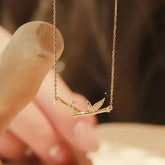 18K gold bamboo branch necklace with lab-grown diamonds on neutral background