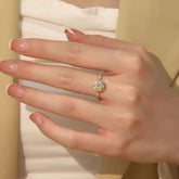 Rose-gold baguette halo diamond ring on hand against beige blazer