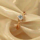 Close-up of gold infinity twist ring on silk, micro-pavé accents shine