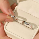 White-gold pavé orbit ring and bezel-solitaire band displayed in ivory jewelry box