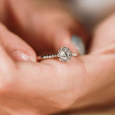 close-up floral wreath halo ring, sparkling pavé diamonds around center stone