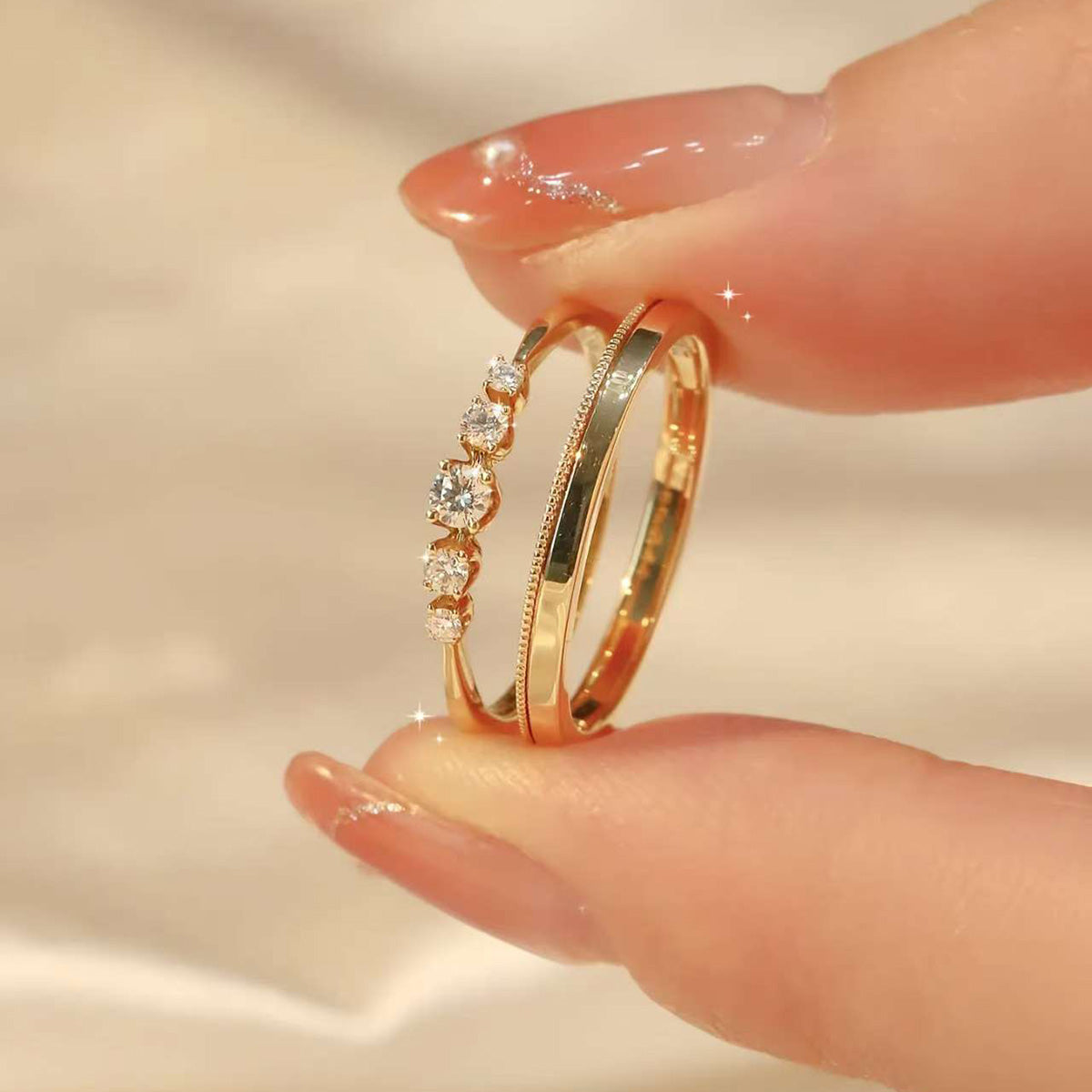 
Close-up of 18K gold couple rings – diamond band and plain milgrain band, delicate sparkle