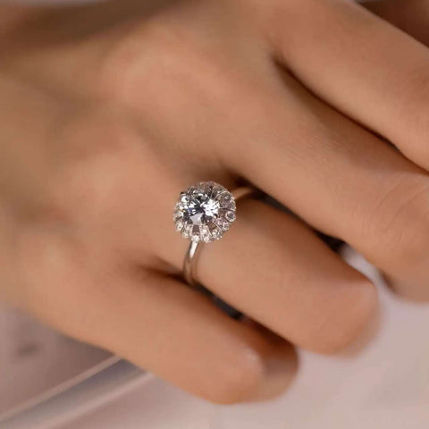 Top view of sunburst baguette halo engagement ring on hand