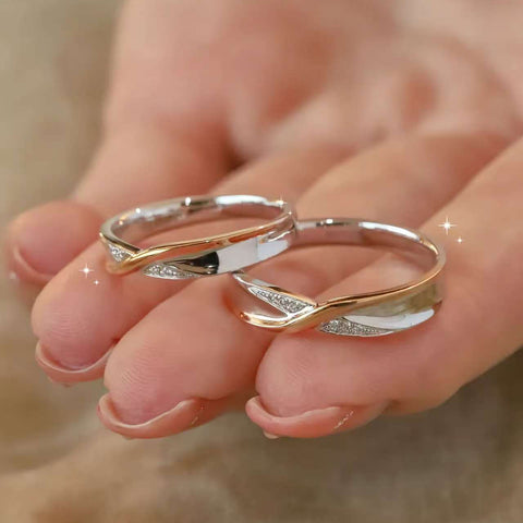 Macro shot of intertwined solid 14k/18k gold rings with diamond accents on fingertips
