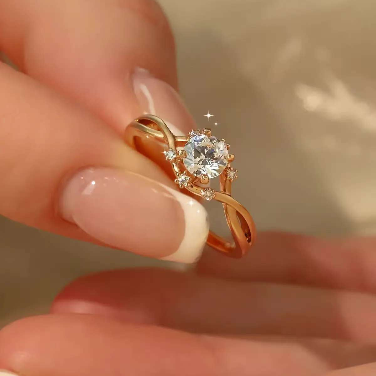 Fingers holding dainty infinity twist diamond ring, side-profile sparkle