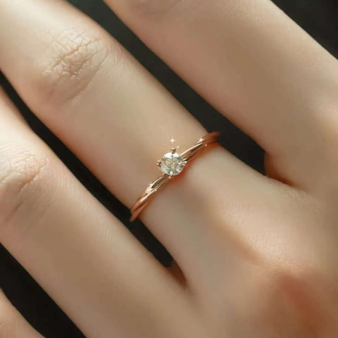 dainty twisted gold solitaire ring worn on finger
