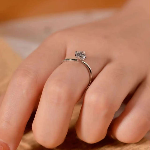 Contemporary solitaire diamond ring worn on hand, highlighting the open arc design