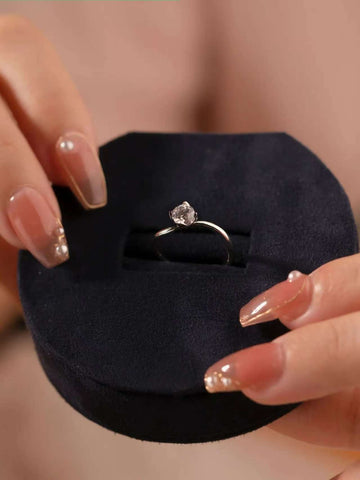 Open arc solitaire ring elegantly displayed in a navy blue ring box