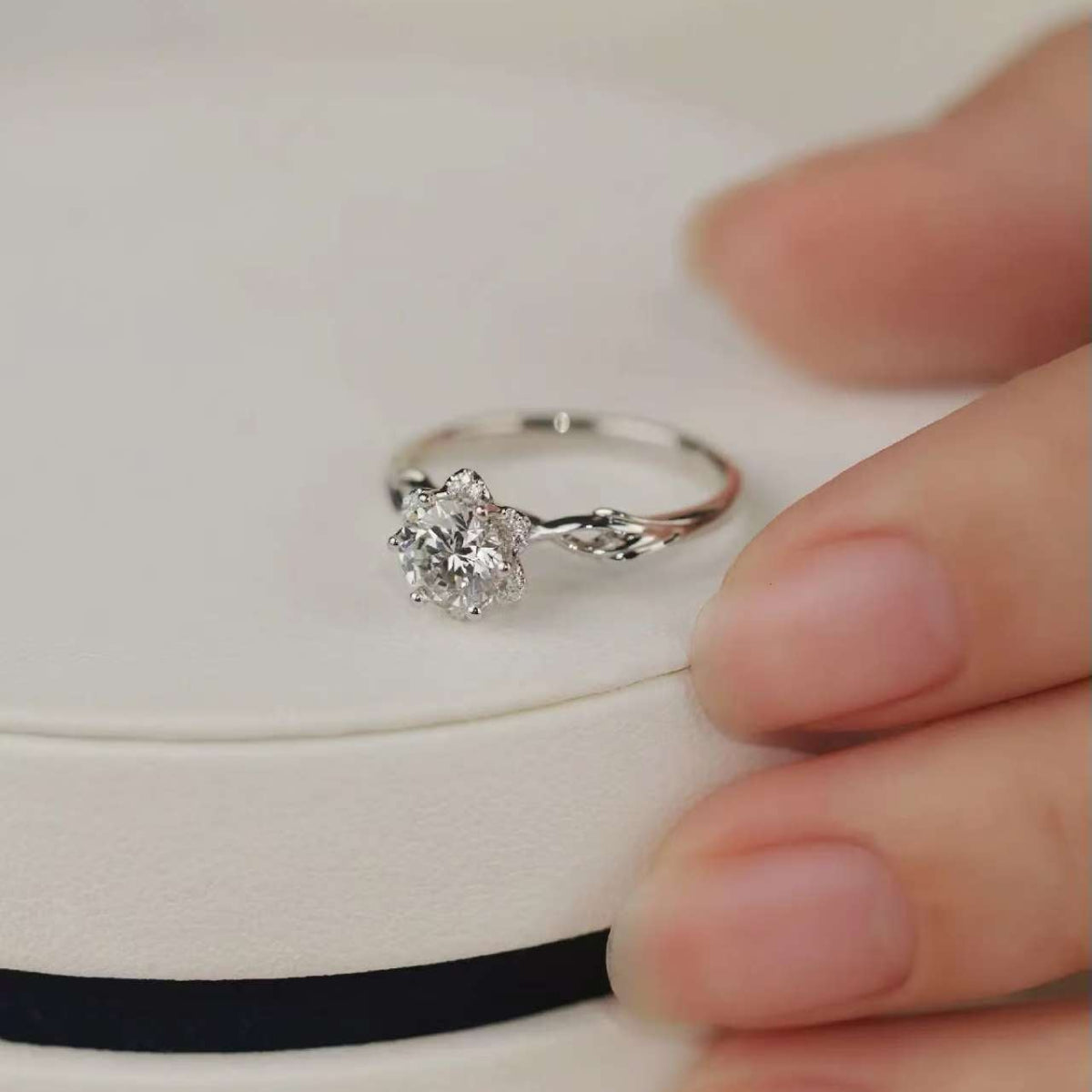 Floral six-prong diamond ring displayed on elegant jewelry box, perfect for proposal or gift.