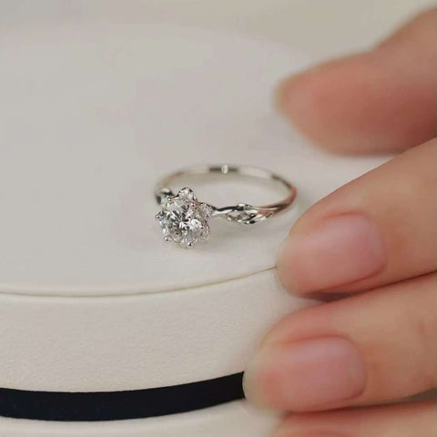 Floral six-prong diamond ring displayed on elegant jewelry box, perfect for proposal or gift.