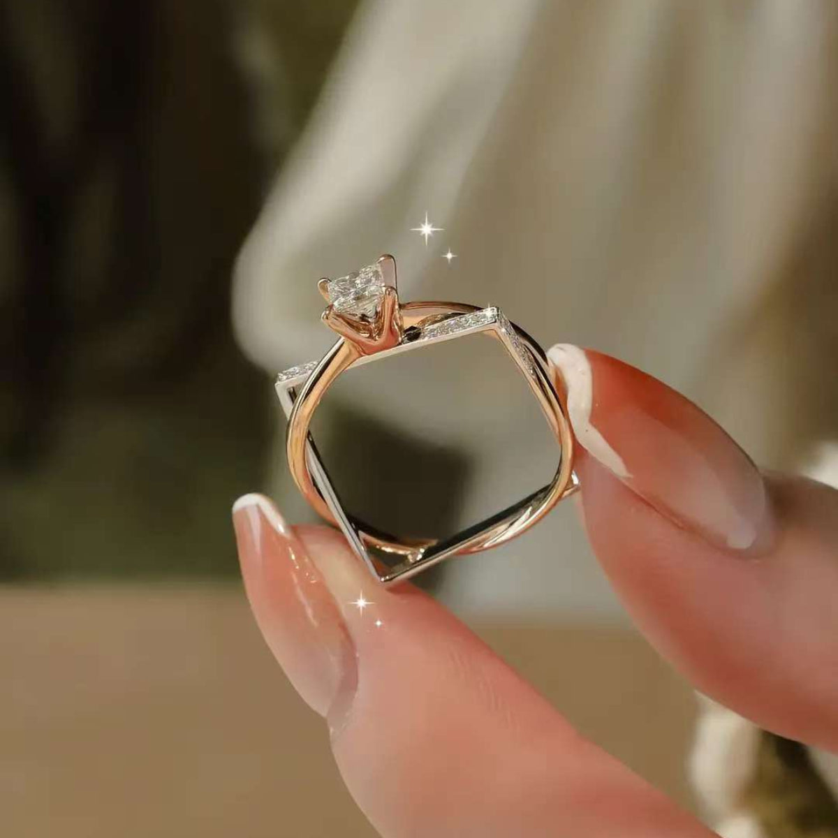 Close-up of rose & white gold frame solitaire with accent diamonds
