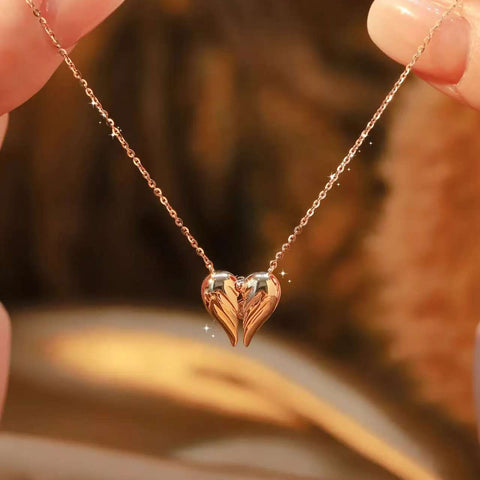 Macro shot of polished 18K gold wings forming a heart pendant