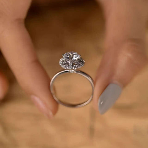 
Hand holding ballerina halo ring, focus on Art-Deco crown detail