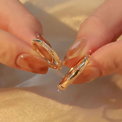 Close-up of pavé bamboo ring and plain bamboo ring between manicured fingers
