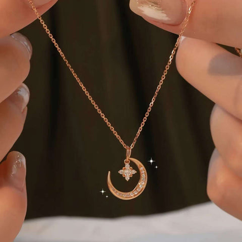 Hand holding rose-gold crescent-moon pendant against a dark, out-of-focus background