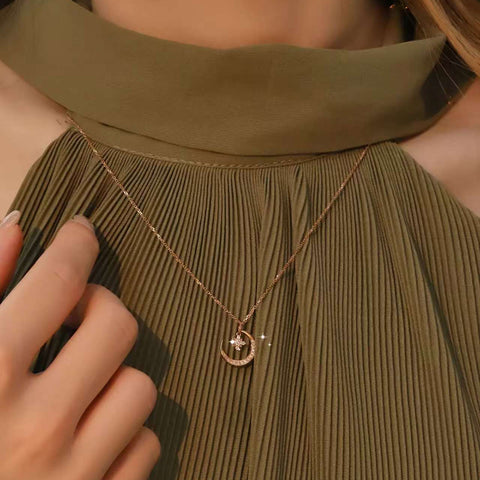 Model adjusting chain; pendant lies on pleated fabric near neckline