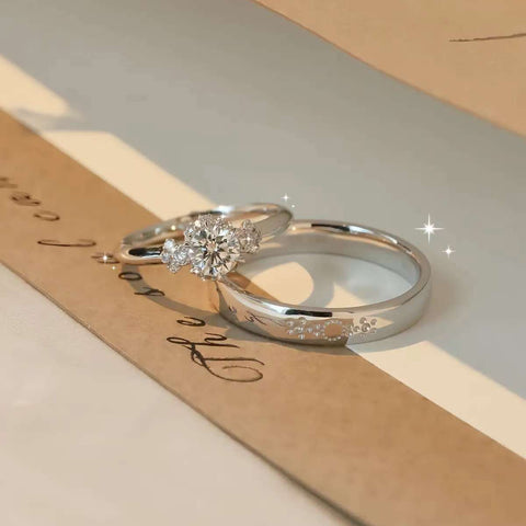 Classic his and hers wedding bands, solitaire diamond ring and matching men’s band, displayed with wedding invitation.
