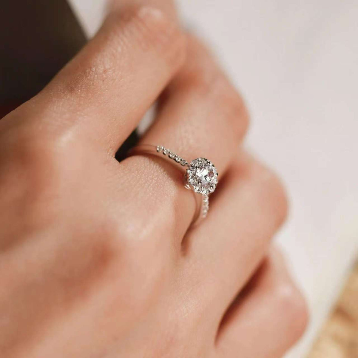 0.60 ct floral halo engagement ring on hand, pavé band, rose-gold setting