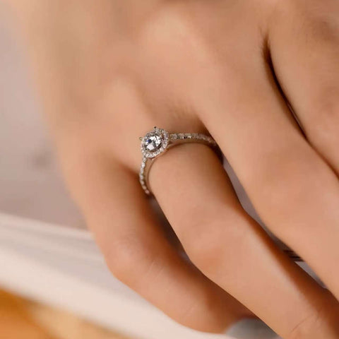 Halo engagement ring worn on finger, micro pave details