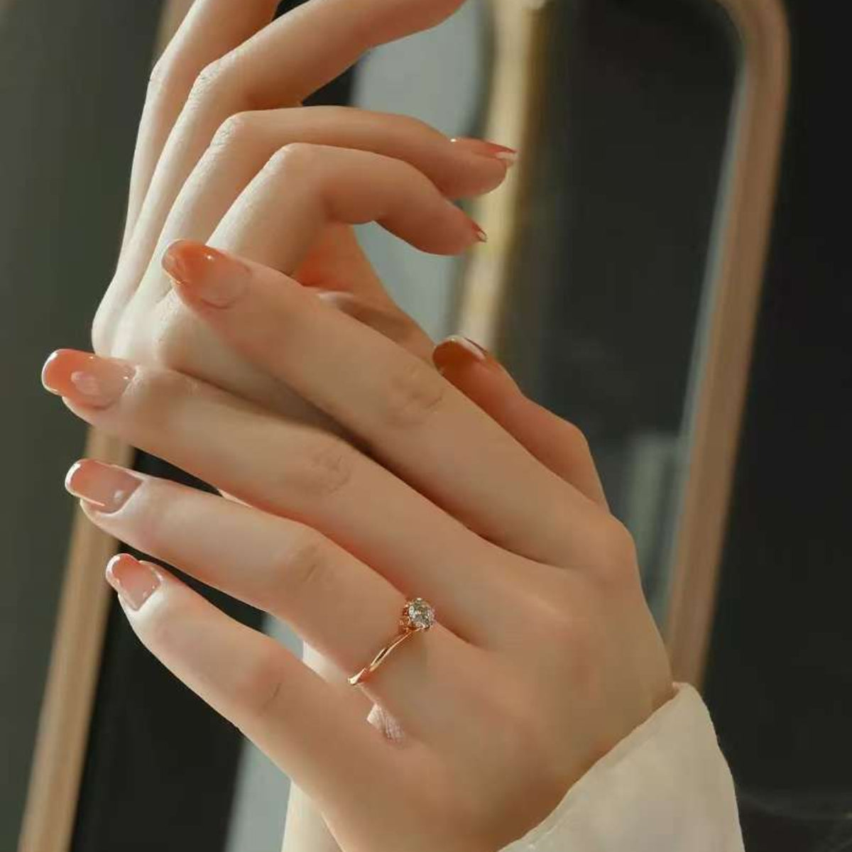 Elegant hands wearing minimalist rose gold solitaire engagement ring
