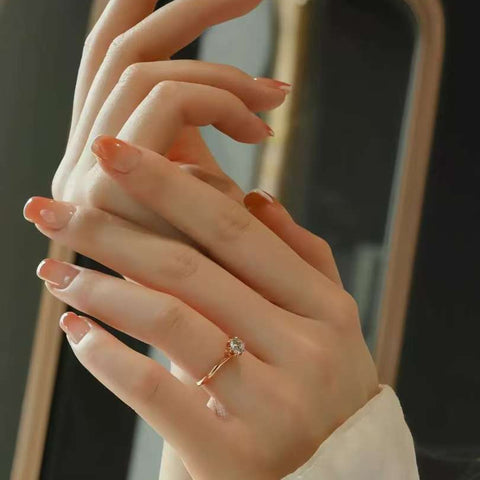 Elegant hands wearing minimalist rose gold solitaire engagement ring
