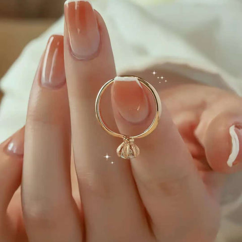 Rose gold diamond ring balanced on fingertip with floral basket detail