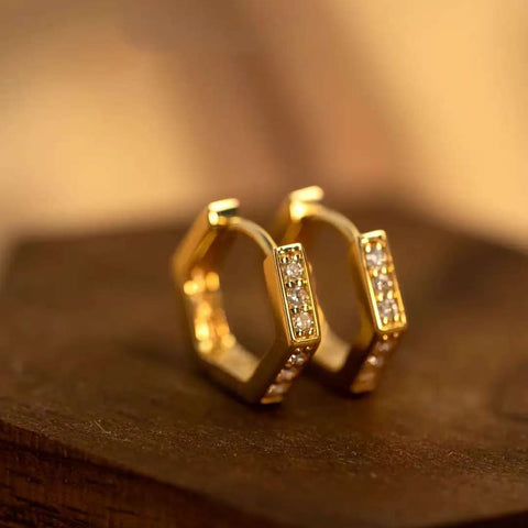 Fingers pinching two hexagon pavé hoops edge-to-edge
