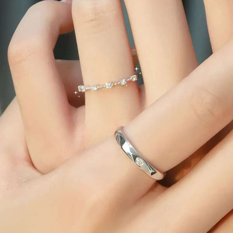 Stackable diamond band and classic men’s wedding ring worn together, romantic hand display.