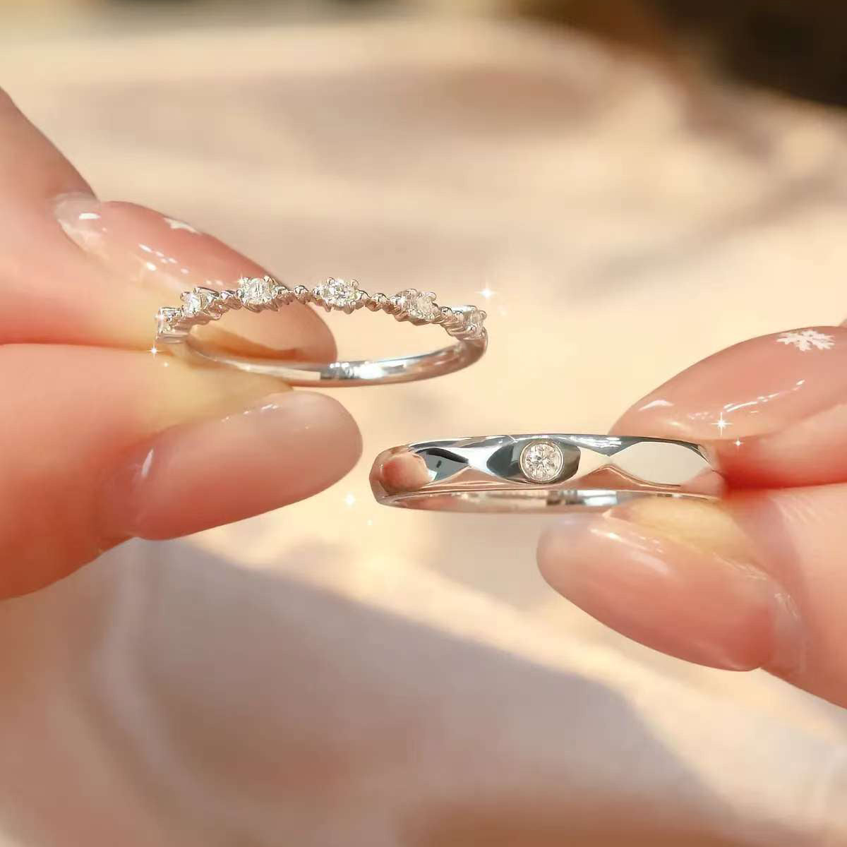 Detailed close-up of women’s eternity band with round diamonds and men’s textured band, both in white gold.