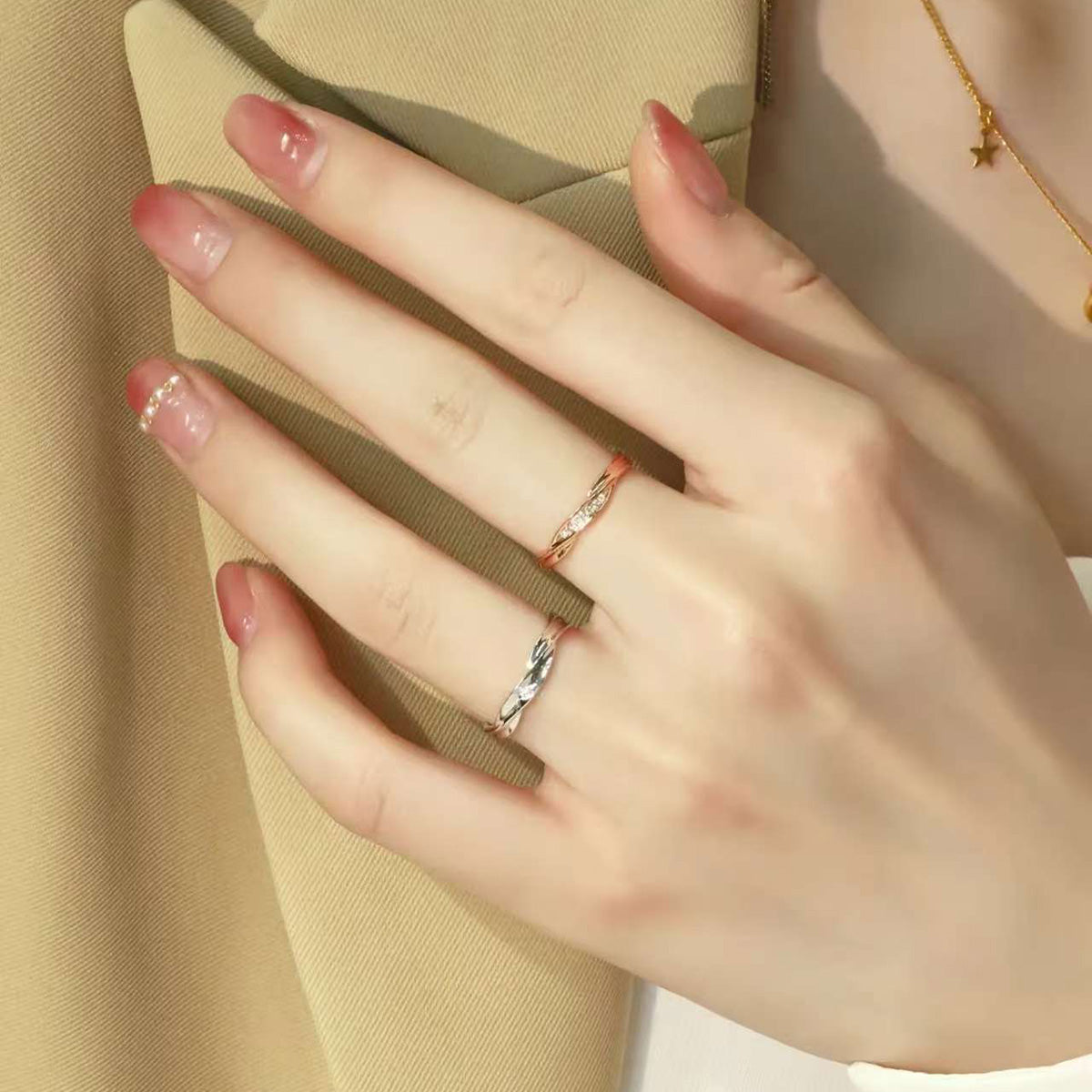 Model’s hand wearing matching rose and white gold twist diamond rings, minimalist couple jewelry