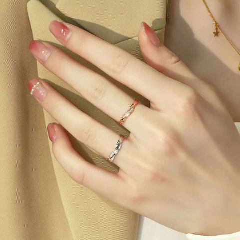 Model’s hand wearing matching rose and white gold twist diamond rings, minimalist couple jewelry