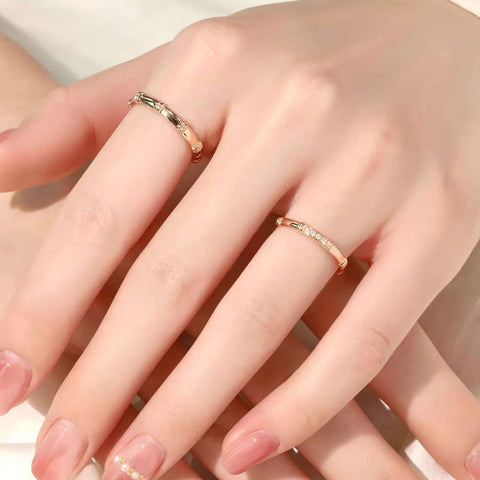 Hand with yellow-gold slim bamboo rings (plain & diamond) on adjacent fingers